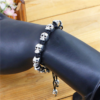 Pulsera tejida, con calaveras sonrientes plateadas